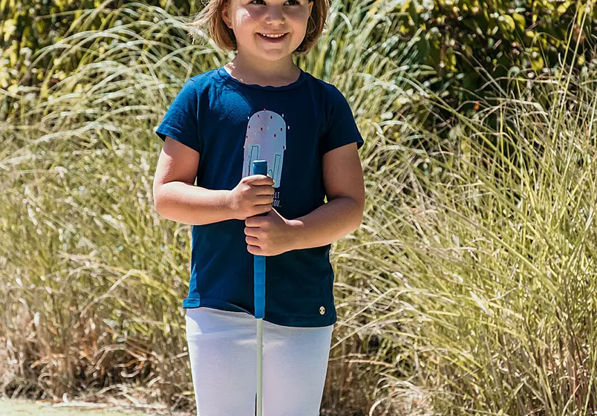 Een blij meisje klaar voor een potje minigolf bij De Zeeuwse Kust