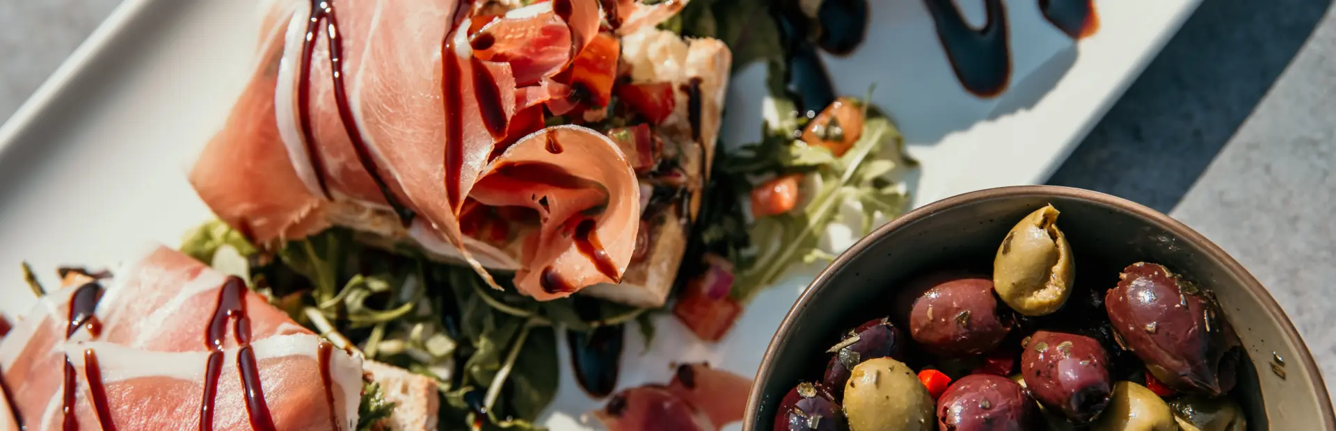 Smaakvolle lunch, knapperig brood met romige topping, omhuld met zachte Parmaham en balsamico