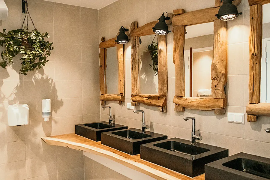 Moderne wastafels in het sanitairgebouw van Strandpark De Zeeuwse Kust, met houten accenten en sfeervolle verlichting.